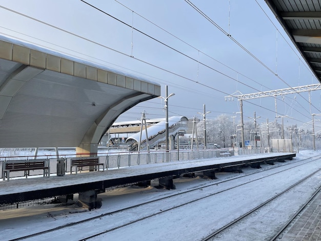 Plataforma ferroviaria vacía sin pasajeros en invierno al atardecer. Ferrocarril, concepto de clima frío