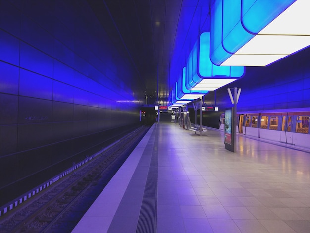 Foto plataforma iluminada de la estación de tren por la noche