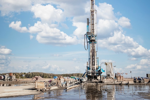 Foto plataforma de perforación en el campo después de la lluvia. perforación de agujeros profundos. trabajos de exploración geológica. exploración de minerales. potente taladro perfora un pozo.