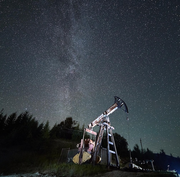 Foto plataforma petrolera por la noche bajo un cielo estrellado