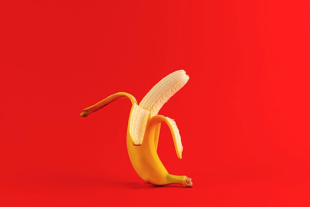 Un plátano abierto, abra la piel de la cubierta de la fruta, superficie colorida aislada, nutrición cruda simple
