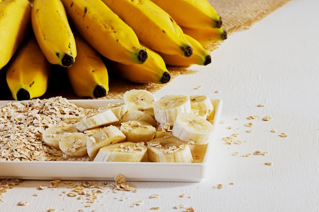 Plátano y avena en un plato y sobre la mesa