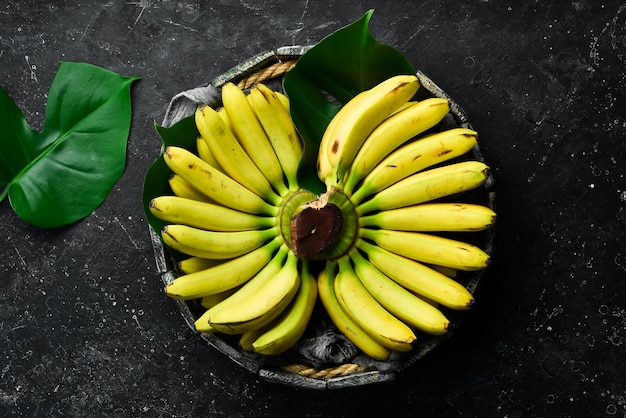 Plátano bebé Conjunto de plátanos en una caja de madera Vista superior Espacio de copia libre