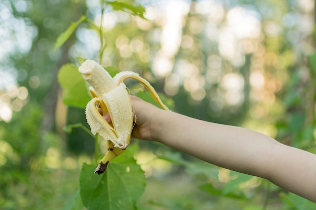 Un plátano en la mano de un niño al aire libre