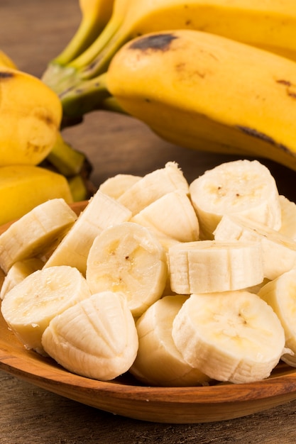 Un plátano de plátanos y un plátano en rodajas en una olla sobre una mesa.