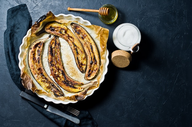 Plátanos al horno con miel en un plato para hornear.