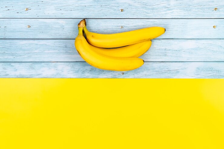 Foto los plátanos amarillos se encuentran sobre un fondo de madera azul y un fondo amarillo