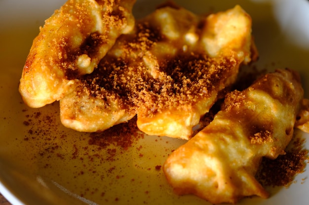 plátanos fritos o buñuelos de plátano con una pizca de azúcar de palma en polvo y canela en polvo.