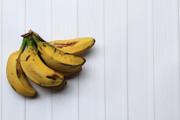 Plátanos saba maduros sobre fondo blanco Composición media
