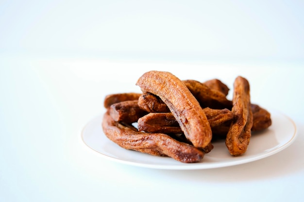 Plátanos secos en un plato blanco sobre un fondo de hormigón