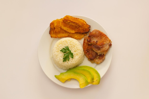 Foto platão almuerzo dominicano, tostones fritos, arroz blanco acompañado de varios aguacates cortados, comida en casa, toma superior