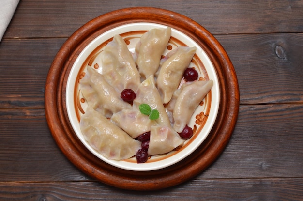 Plato con albóndigas con cerezas sobre una mesa de madera plana