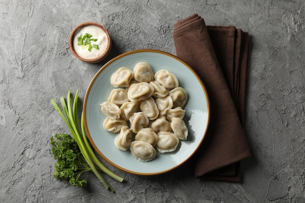 Plato con albóndigas, toalla y especias sobre fondo gris, vista superior