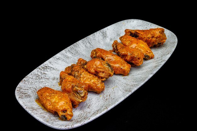 Foto plato de alitas de pollo buffalo sobre fondo negro