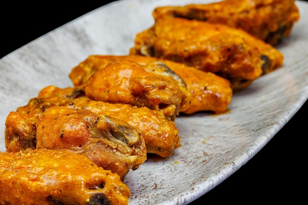 Foto plato de alitas de pollo buffalo sobre fondo negro