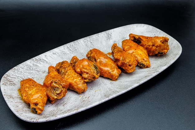 Foto plato de alitas de pollo buffalo sobre fondo negro