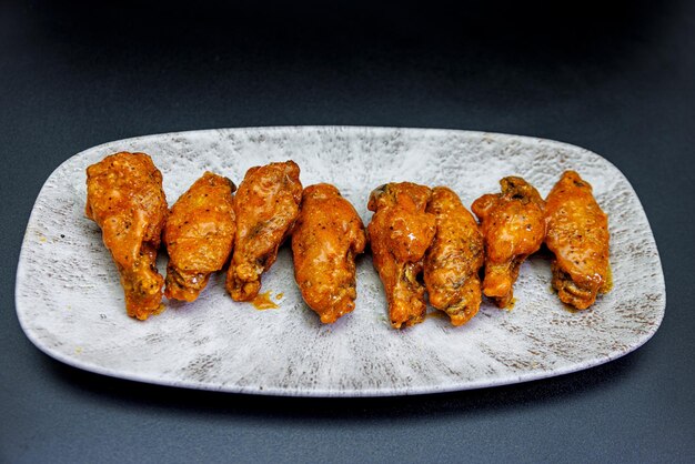 Foto plato de alitas de pollo buffalo sobre fondo negro