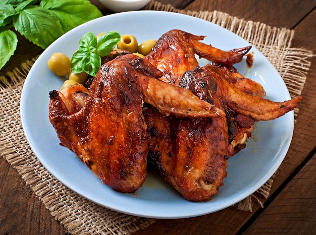 Plato de alitas de pollo en la mesa de madera