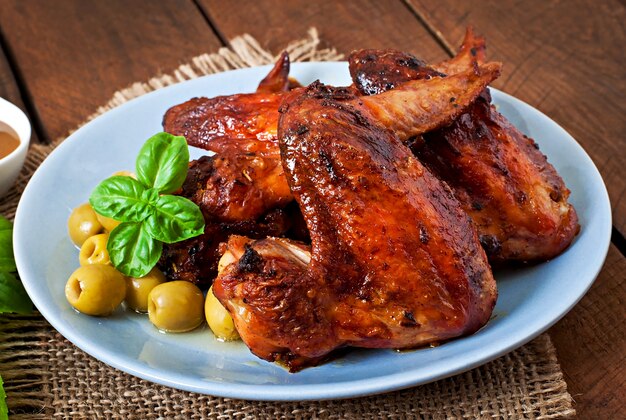 Plato de alitas de pollo en la mesa de madera