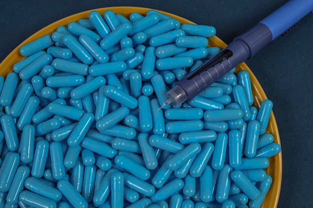 Plato amarillo lleno de cápsulas de medicamentos azules que representan una sobredosis de drogas.