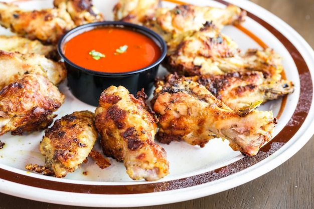 Plato de aperitivo con alitas de pollo al horno de leña.