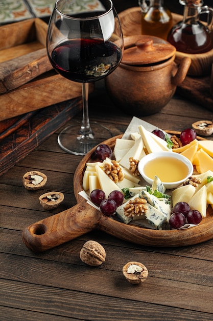 Foto plato de aperitivo de queso con uvas y miel