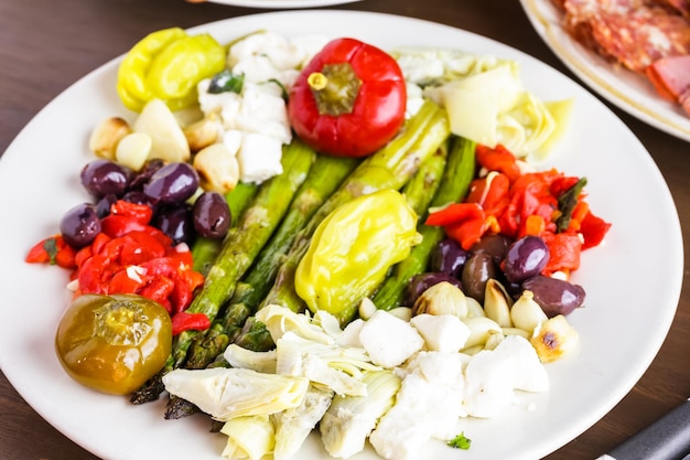 Plato de aperitivos con antipasto vegetariano en restaurante italiano.