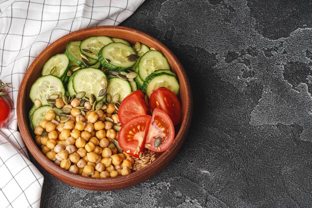 Foto plato de arcilla de garbanzos y pepinos y tomates cortados. alimentación saludable