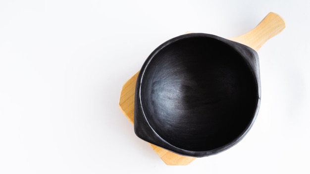 Plato de arcilla negra sobre un plato de madera