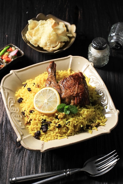 Plato de arroz Biryani con papadom de pollo frito en escabeche y ensalada de comida tradicional india o