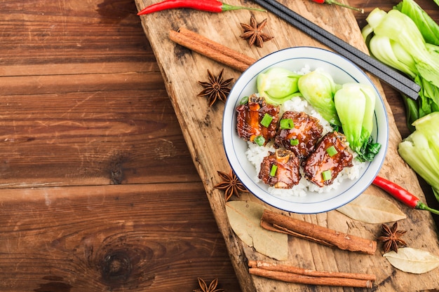 Un plato de arroz con costillas en salsa marrón