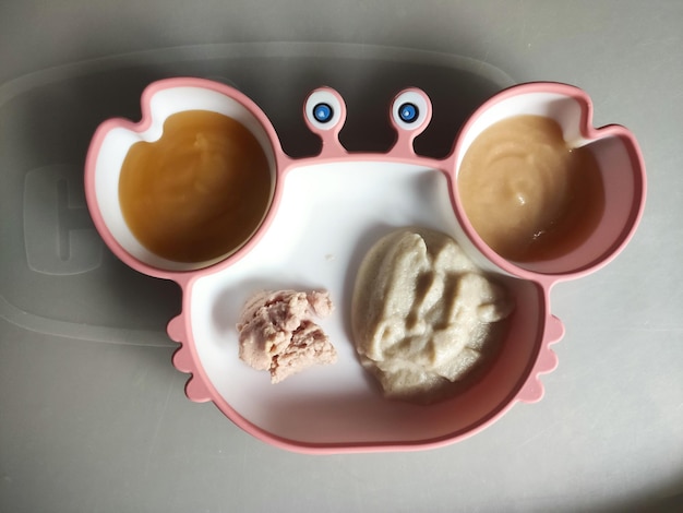 Un plato de bebé con puré de comida para bebés en la mesa