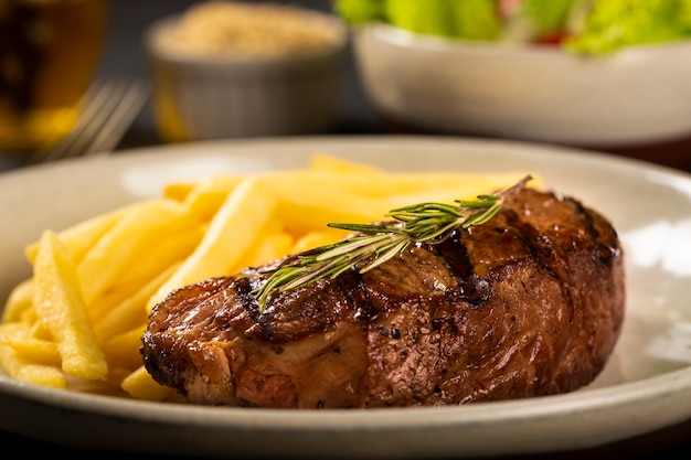 Plato con bistec a la parrilla y papas fritas