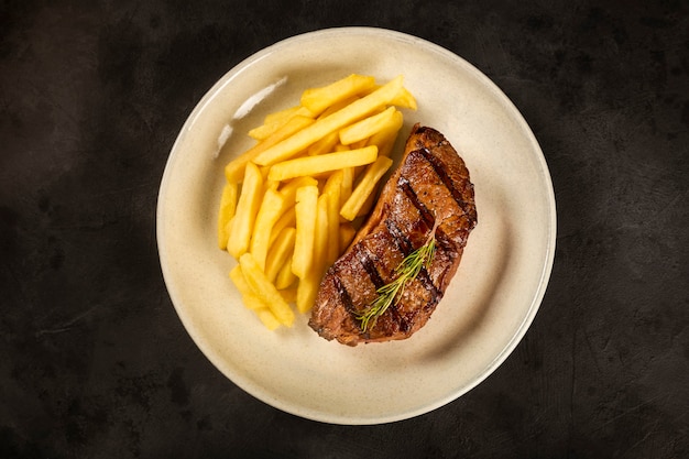 Plato con bistec a la parrilla y papas fritas