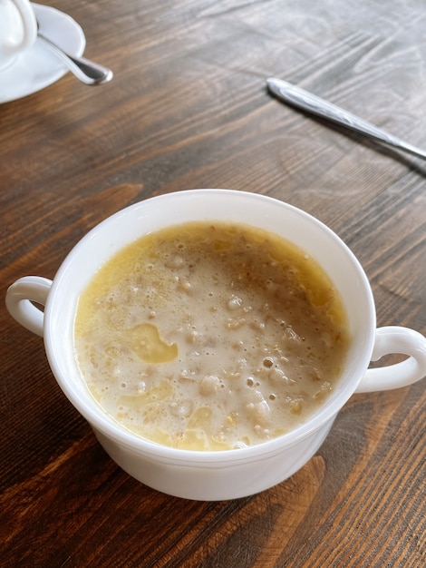 Plato blanco con avena en el fondo de madera