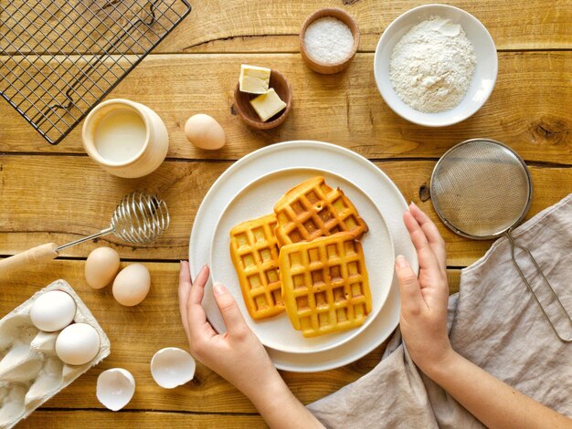 En un plato blanco se cocinan gofres recién hechos para el desayuno.