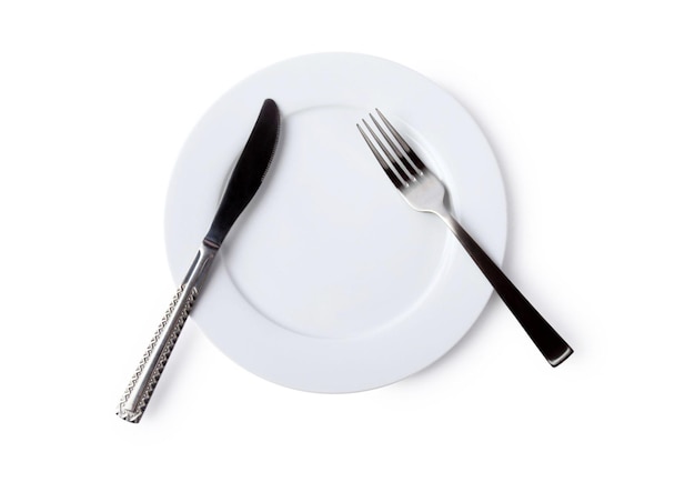 Un plato blanco cuchillo y tenedor sobre un fondo blanco.