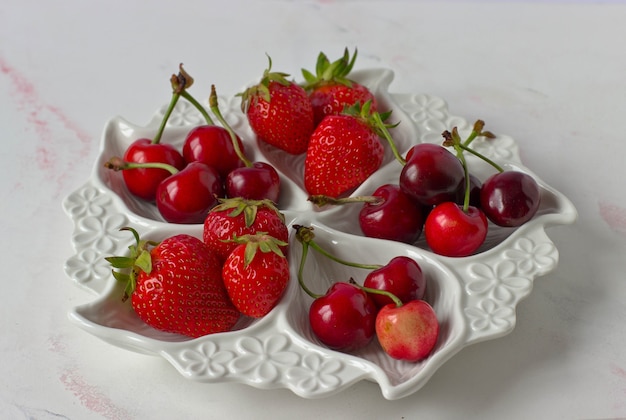 Plato blanco dividido con fresas y cerezas