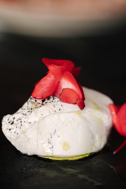 Un plato blanco con una flor roja encima.