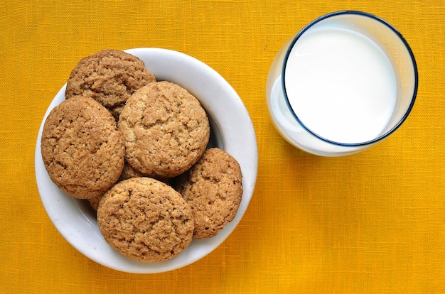 Plato blanco con galletas de avena y vaso con leche