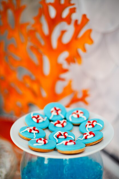 Plato blanco grande con muchas galletas de pan de jengibre con glaseado azul brillante