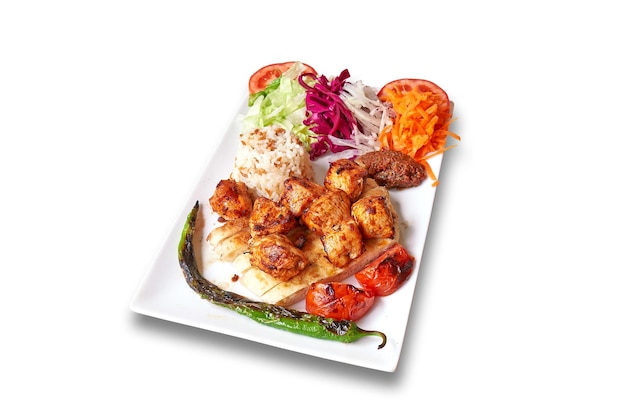 Plato blanco con kebab de pollo y verduras aislado en blanco