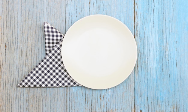 Foto plato blanco en mantel sobre fondo de mesa de madera