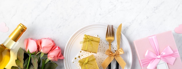 Plato blanco con regalo y rosas rosadas para San Valentín