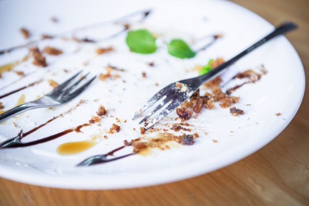 Plato blanco y restos de comida después de comer.