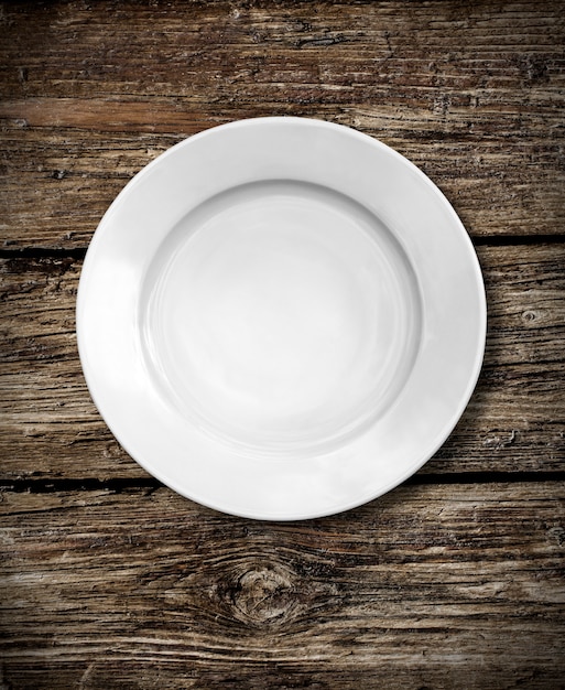 Foto plato blanco sobre fondo de madera