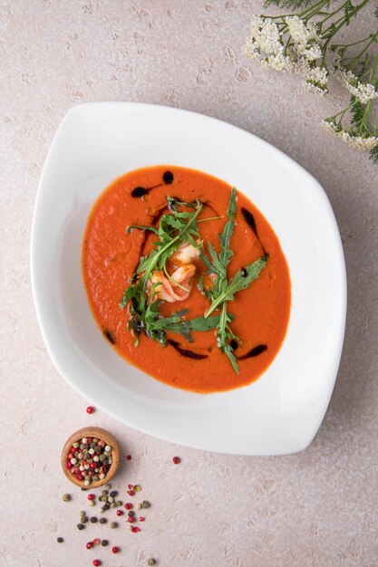 Plato blanco y sopa de tomate con ensalada sopa de tomate casera fresca caliente ensalada de verduras