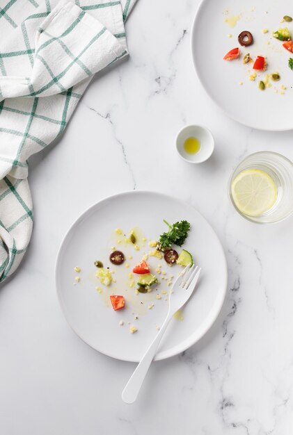 Plato blanco sucio vacío con ensalada de verduras