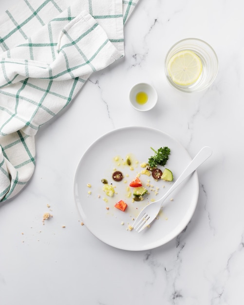 Plato blanco sucio vacío con ensalada de verduras