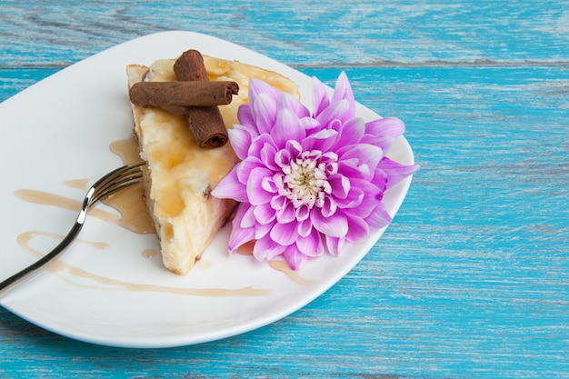 Plato blanco con un trozo de tarta de queso